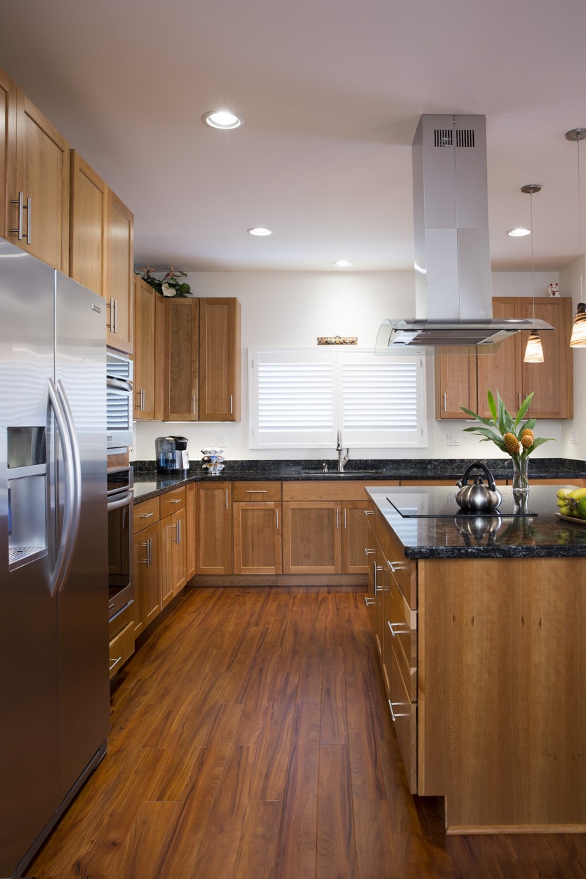 A vinyl plank that has the look of natural wood was used in the kitchen and the adjoining rooms leading out to the pool area due to constant water exposure.