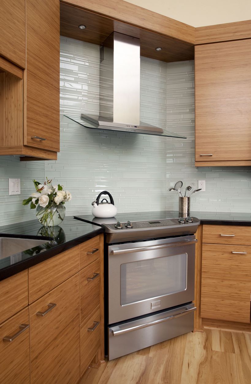 Remodeling the countertops with natural stone, beautiful bamboo cabinets and wood-plank vinyl flooring added snazzy updates to this contemporary home remodel.