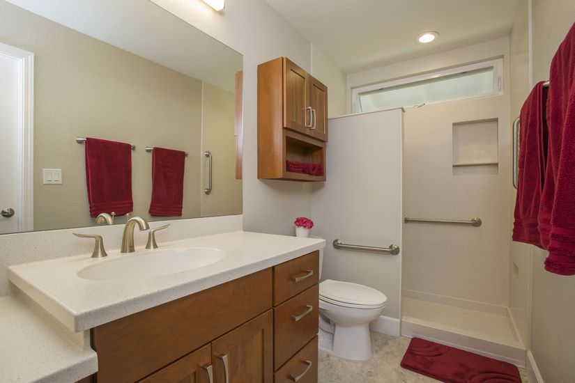  The master bathroom features solid surface countertops by HI-MACS and aging-in-place features such as grab bars and a walk-in shower.