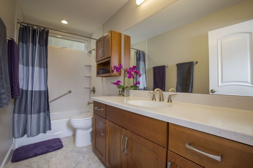 The hall bathroom also featured solid surface HI-MACS countertops and grab bars, with Shaker style cherry cabinets from Diamond.